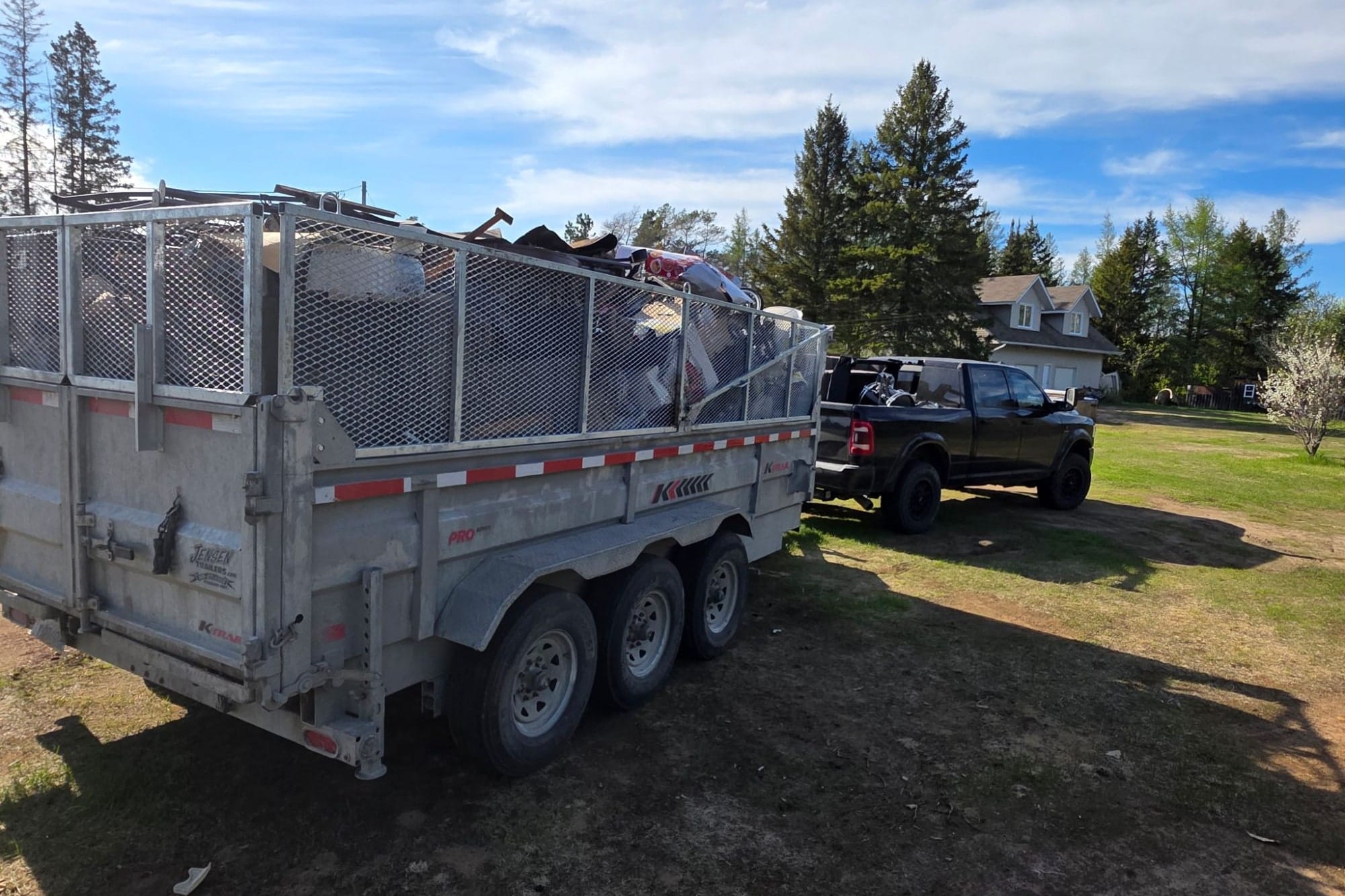 TCM Junk Removal trailer loaded with junk at a Sudbury property — basement & garage cleanouts in Sudbury